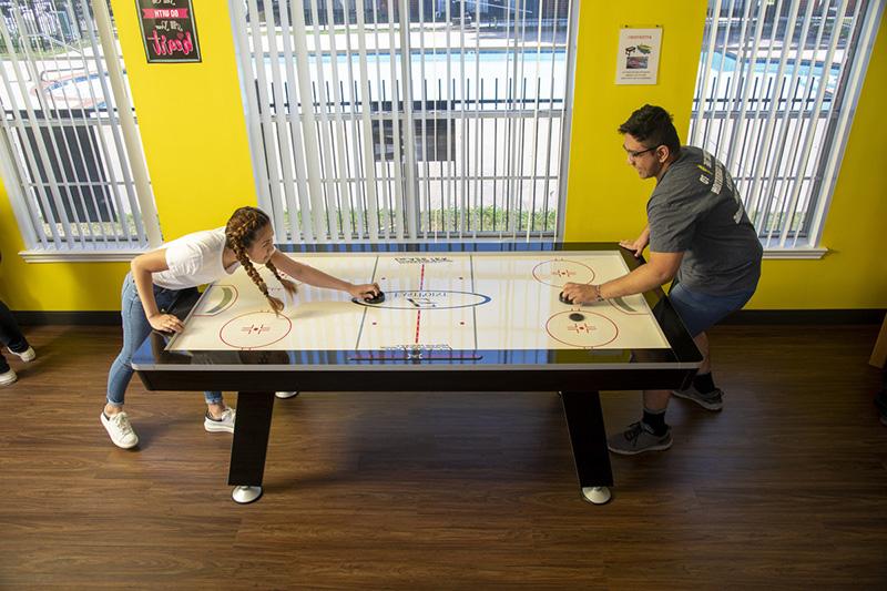 Residents play air hockey in Student Housing activity center